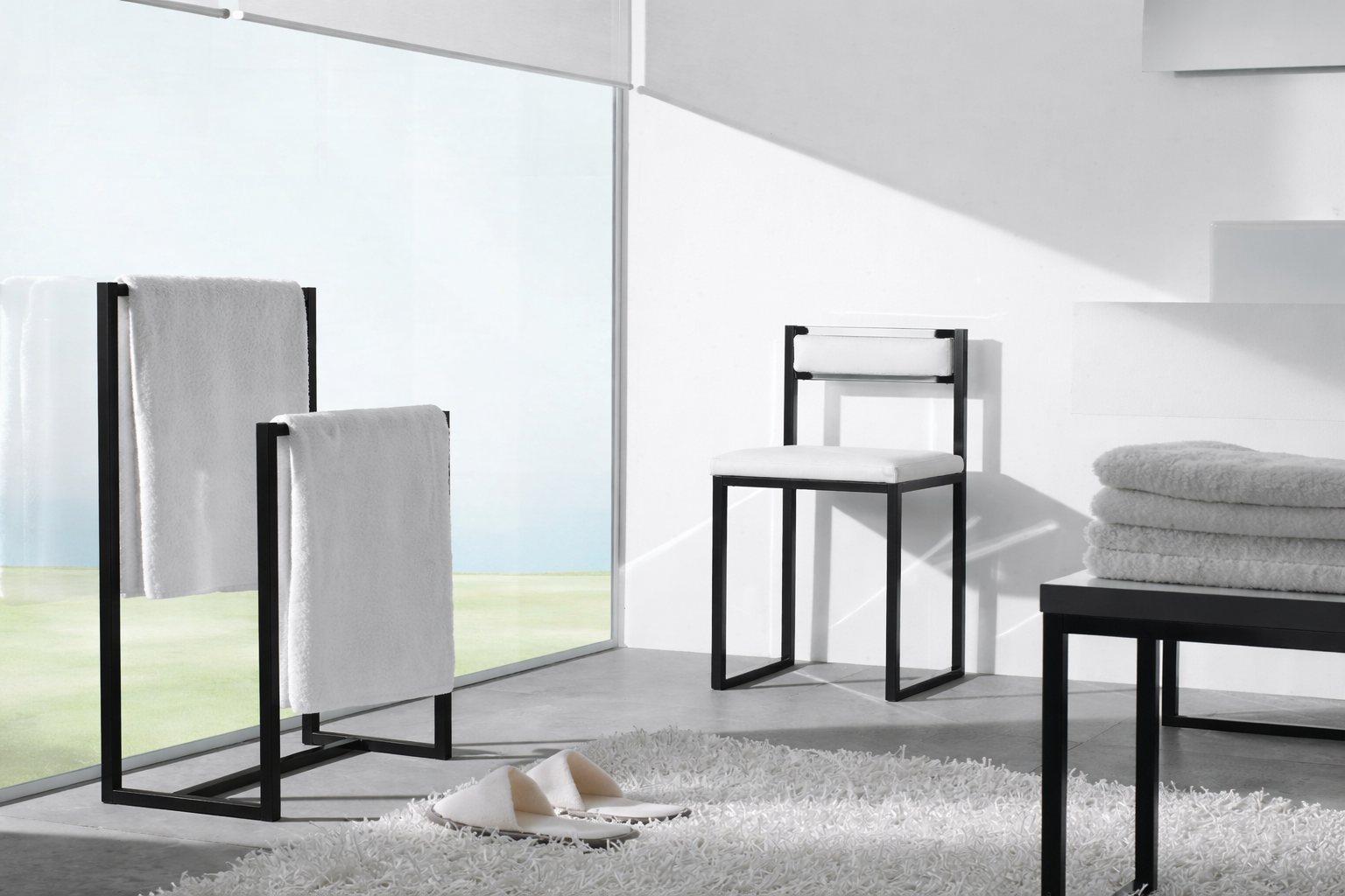 Mobiliario de baño con estructura metálica en negro mate: toalleros, silla y banco
