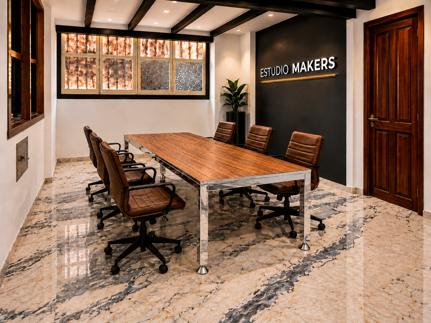 Sala de reuniones Estudio Makers con mesa metálica cromada y sillas de cuero