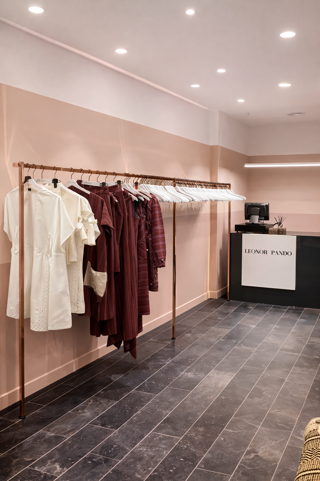 perchero metálico cobre con prendas en boutique Leonor Pando