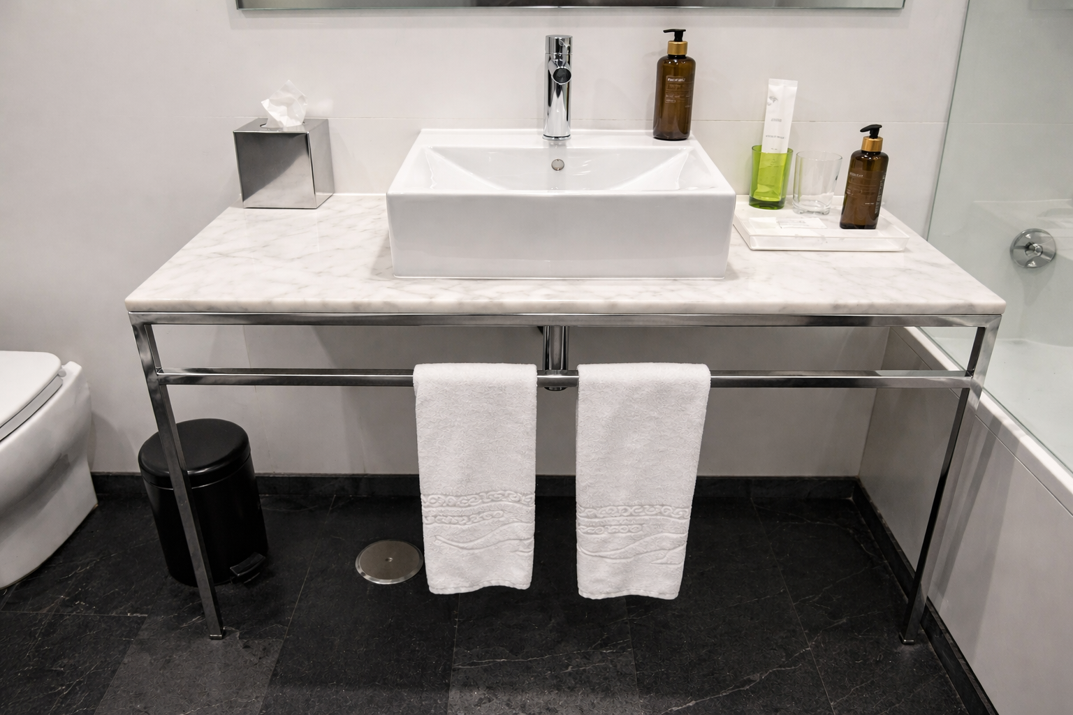 mobiliario metálico para baño de hotel con estructura cromada y mármol